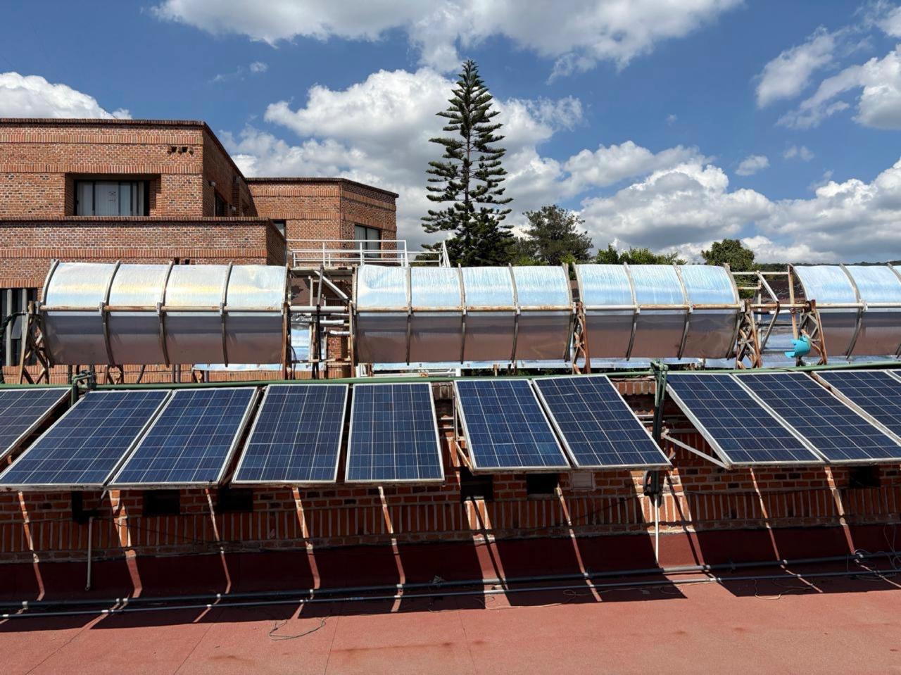 Figura 2. Sistema de paneles fotovoltaicos (al frente) y concentradores de calor (atrás) colocados en el CIICAp UAEM.