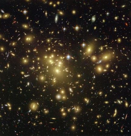 Figura 1. La imagen muestra un cúmulo agrupando a miles de galaxias. Nótese que incluso los puntos luminosos mas pequeños corresponden a una o varias galaxias.